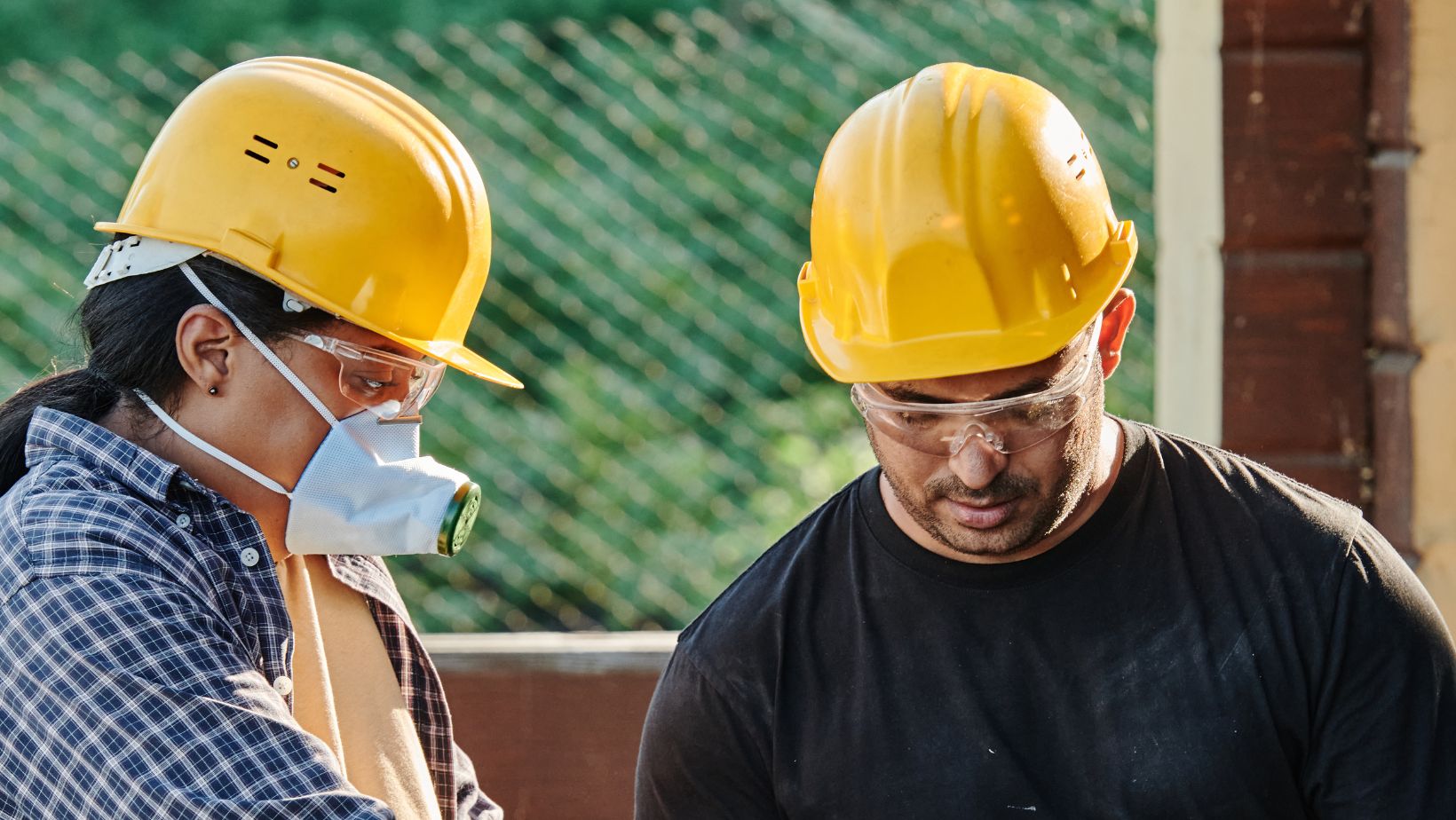 Man and woman wearing head PPE